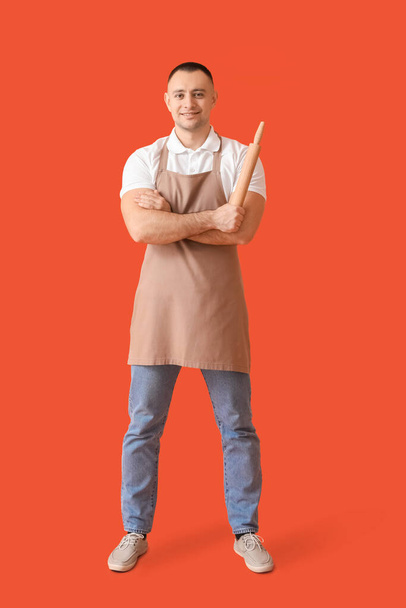 Young man with rolling pin on color background - Фото, зображення