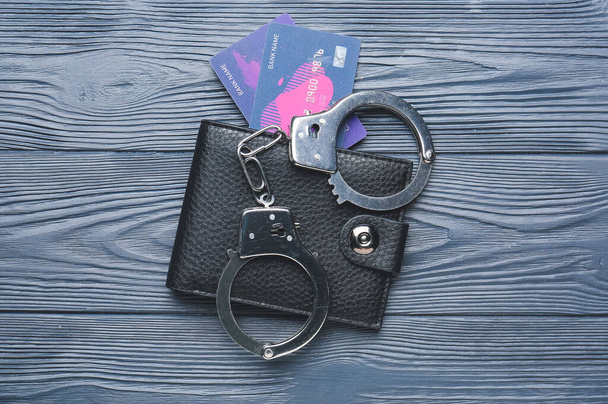 Portefeuille avec poignets et cartes de crédit sur fond bois foncé - Photo, image