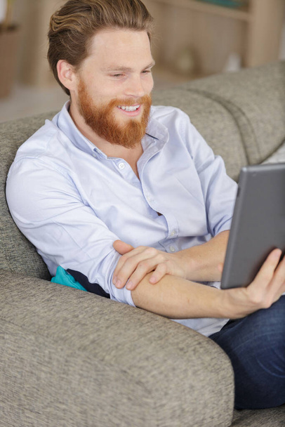 handsome man using a digital tablet and smiling - Foto, imagen