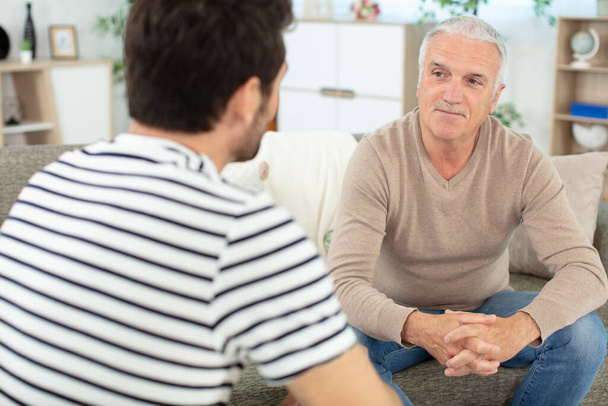 old father talking with son having pleasant conversation - Photo, Image