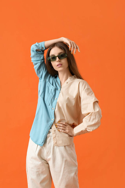 Schöne junge Frau mit stylischer Sonnenbrille auf farbigem Hintergrund - Foto, Bild