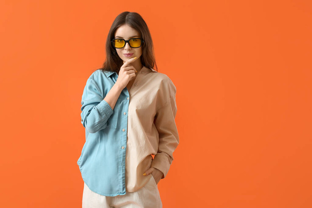Beautiful young woman with stylish sunglasses on color background - Foto, afbeelding