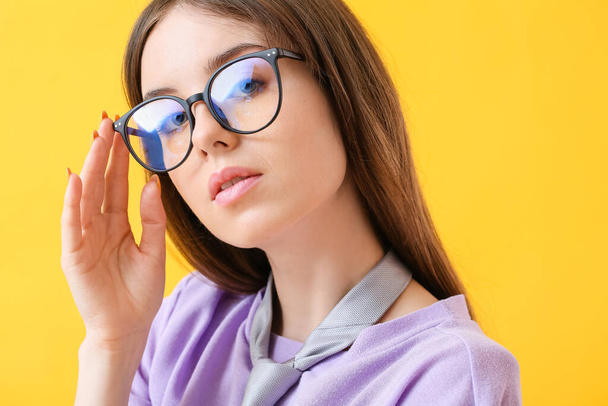 Young woman wearing eyeglasses on color background - Foto, Imagem