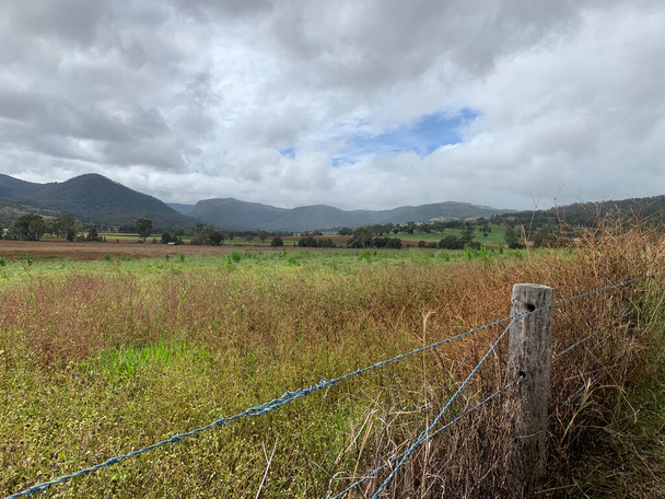 Kilátás a vidékre a Southern Down régióban Queensland Ausztrália. Gördülő dombokkal, zöld paddokkokkal és kerítésekkel - Fotó, kép