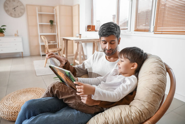 Isä ja pieni poika lukemassa kirjaa kotona - Valokuva, kuva