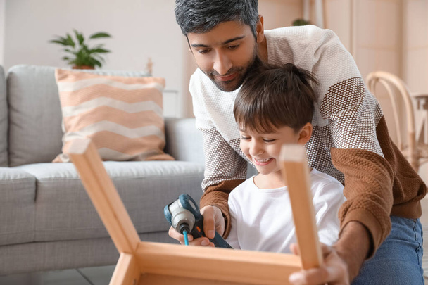 家で椅子を修理する父と息子 - 写真・画像