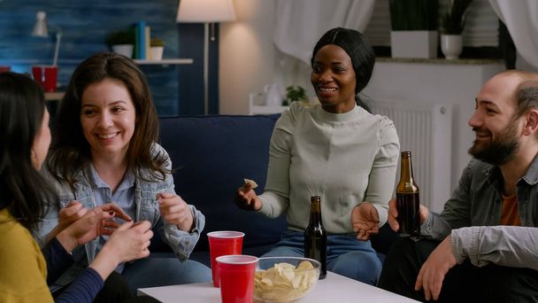 Multikulturelle Freunde lachen, während sie Lifestyle-Ratschläge auf der Couch austauschen - Foto, Bild