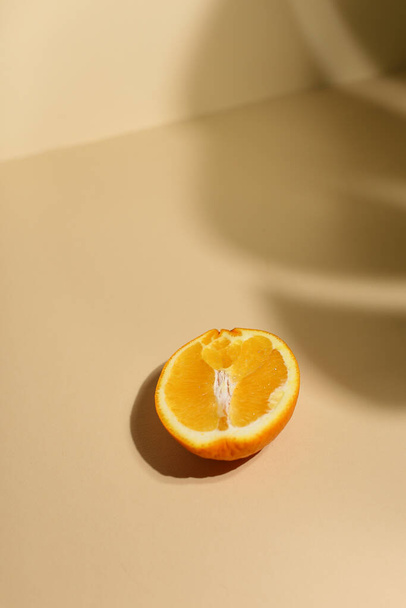 Кусочек свежего апельсина на бежевом фоне - Фото, изображение