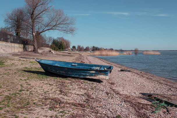 barca blu su una spiaggia rocciosa in riva al lago - Foto, immagini