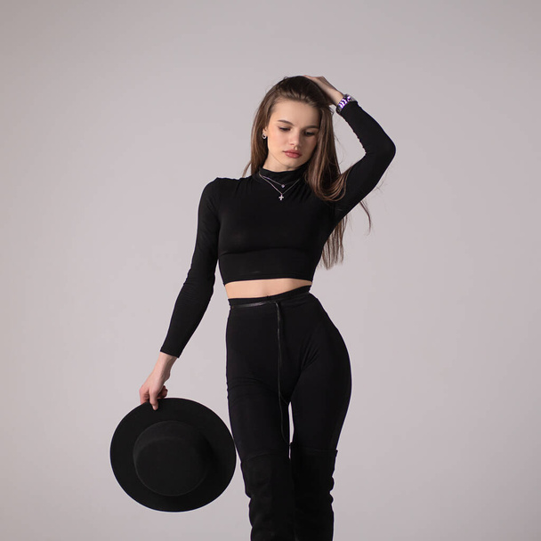 Stylish girl in black costume in studio - Фото, изображение