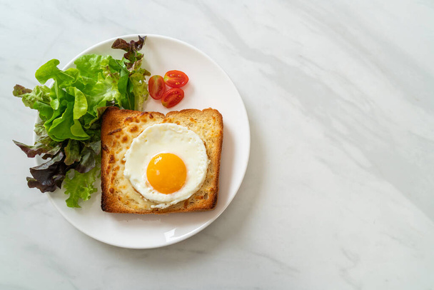 домашній хліб, підсмажений з сиром і смаженим яйцем зверху з овочевим салатом на сніданок
 - Фото, зображення