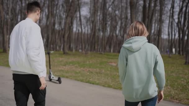 High five. A young couple is riding electric scooters and having fun. - Materiał filmowy, wideo