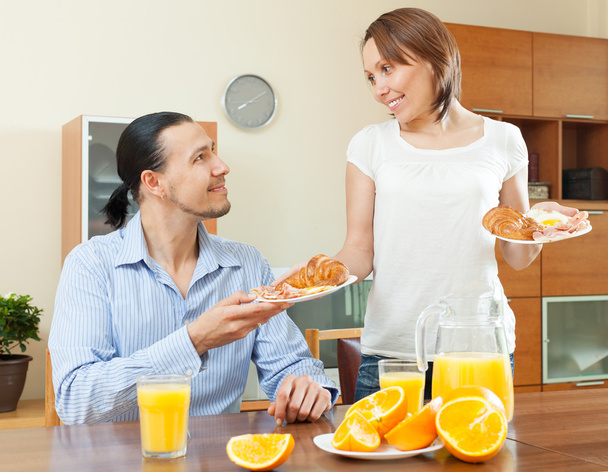 uśmiechający się serwuje śniadanie jej mężczyzna  - Zdjęcie, obraz