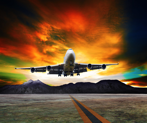Avion jet survolant les pistes contre la montagne rocheuse et beau ciel sombre avec copie utilisation de l'espace pour le transport aérien, voyage et voyage d'affaires de l'industrie
 - Photo, image
