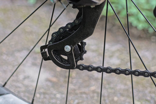 ένα μαύρο γρανάζι πίσω σιδερένια αλυσίδα σε ένα σπορ ποδήλατο τροχό σε εξωτερικούς χώρους - Φωτογραφία, εικόνα