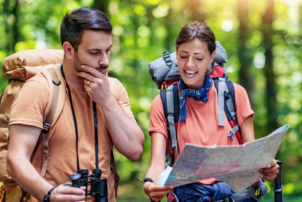 Coppia di escursionisti che leggono una mappa durante il trekking nella natura.Natura, stile di vita, persone e tempo libero concetto. - Foto, immagini