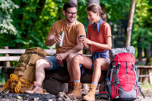 Casal jovem acampando na floresta juntos. Esporte, natureza, amor e férias conceito. - Foto, Imagem