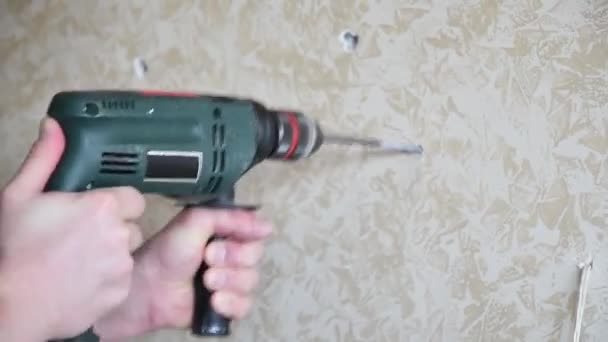 Manos de hombre trabajan con herramienta de taladro para hacer agujero en la pared. Mejora del hogar - Metraje, vídeo