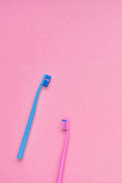 Produits d'hygiène dentaire et de soins buccodentaires sur fond rose et bleu avec espace de copie. Brosses à dents Pose plate, composition vue du dessus, maquettes - Photo, image
