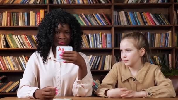 Individuele leraar geeft les aan schoolmeisjes brieven met flashcards - Video