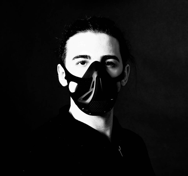 Jonge man model met masker poseren in studio. Fantasie, Halloween, Sci-Fi concept. - Foto, afbeelding