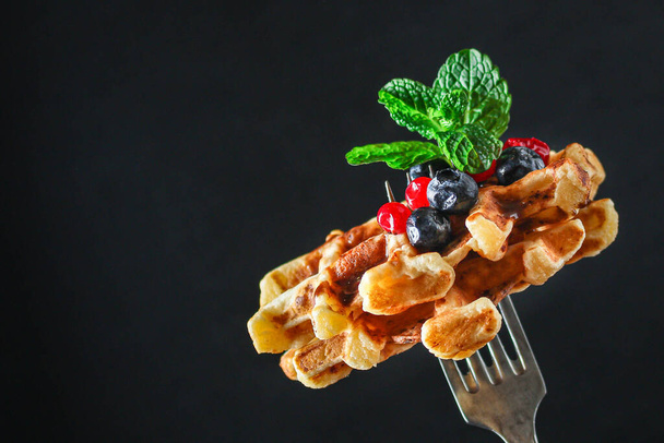 belgium waffles with berries and mint leaves on dark background - Photo, Image