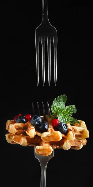 вафли из бельгия с ягодами и мятными листьями на темном фоне - Фото, изображение