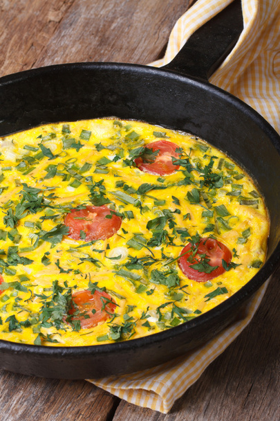 Frittata with green onions, tomatoes in a pan closeup - Fotó, kép