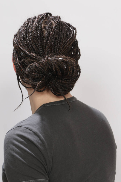 Стильна чоловіча модель з афро косами позує в студії на ізольованому фоні. Стиль, тенденції, концепція моди
. - Фото, зображення