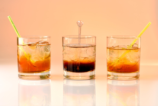 three cocktails on orange background, god mother, Black Russian and god father in glass with ice - Photo, Image