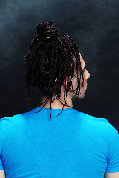 Stylish male model with afro braids posing in studio on isolated background. Style, trends, fashion concept. - Photo, Image