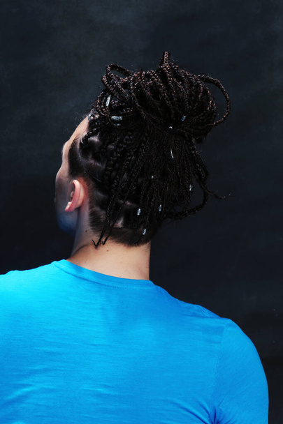 Stylish male model with afro braids posing in studio on isolated background. Style, trends, fashion concept. - Foto, immagini