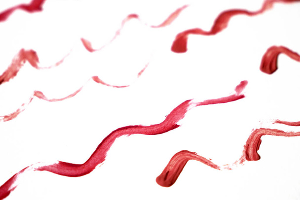 Liquid lipstick on white background, red liquid lipstick with a single color swipe, closeup - Fotó, kép