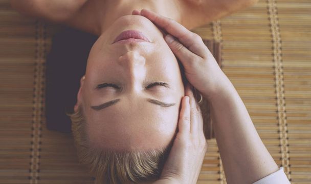 Young woman enjoying massage in spa salon - Фото, изображение