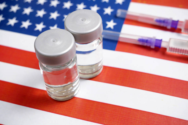 Spritze mit Impfstoff auf Hintergrund der US-Flagge, Impfstoff gegen Coronavirus covid-19, Konzept, Nahaufnahme - Foto, Bild
