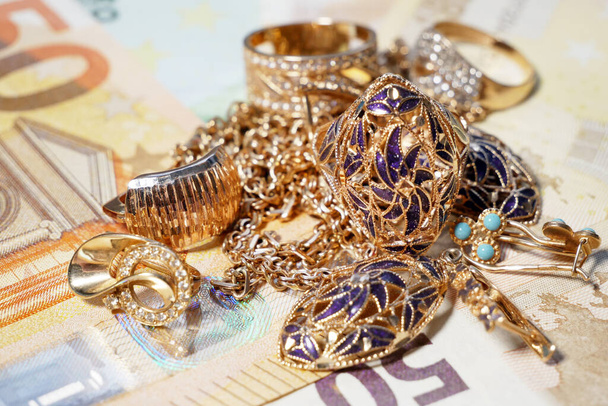 golden jewelry and stack of money, pawnshop concept, closeup - Photo, Image