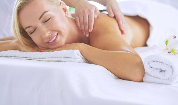 Young woman enjoying massage in spa salon - Zdjęcie, obraz