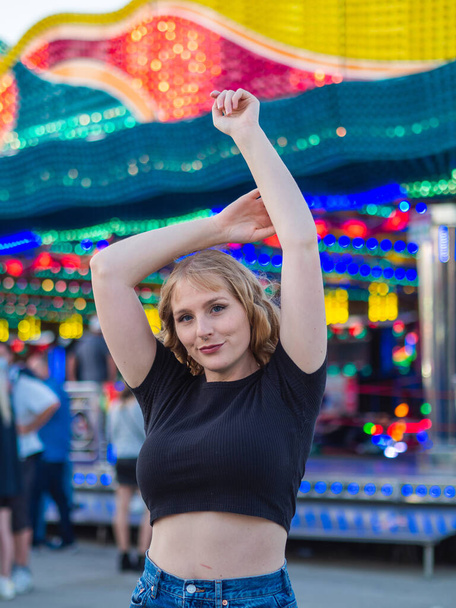 A vertical shot of a young blonde female at an amusement park - Foto, Bild