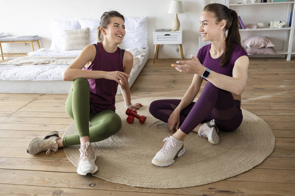 Two athletic caucasian young women doing sports at home. Healthy lifestyle concept - Fotografie, Obrázek