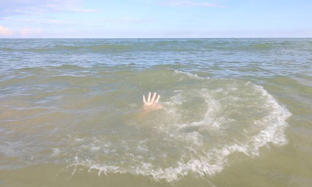 Hand der Person, die im Ozean zu ertrinken droht, weil sie nicht schwimmen kann - Foto, Bild