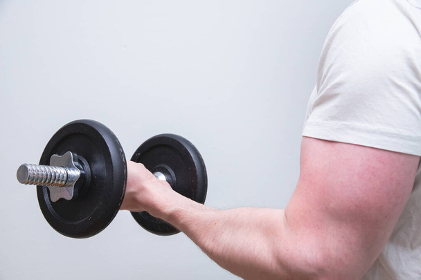 A closeup shot of a male exercising with a dumbbell - Foto, immagini