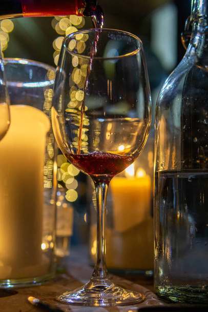 A closeup shot of red wine pouring into a glass - Valokuva, kuva