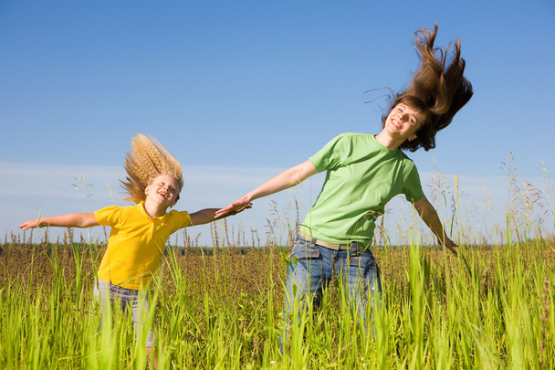Gelukkige vrouw en meisje maken oefeningen op veld. - Foto, afbeelding