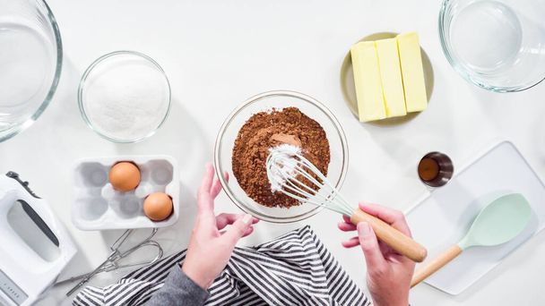Step by step. Flat lay. Mixing ingredients in a glass mixing bowl to bake chocolate cookies. - Photo, Image