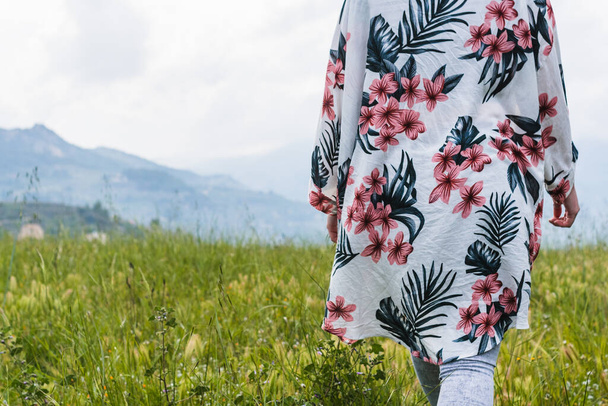 A female with a flowery jacket walking in nature - Valokuva, kuva