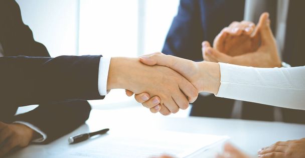 Επιχειρηματίες ή δικηγόροι να σφίγγουν το χέρι τελειώνοντας μια συνάντηση σε μπλε τονισμένο γραφείο, κοντινό πλάνο. Επιτυχία στις διαπραγματεύσεις και τις έννοιες της χειραψίας - Φωτογραφία, εικόνα