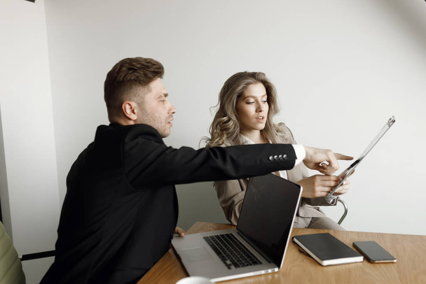 Чоловік і жінка обговорюють ділові питання. Пара, яка працює на ноутбуці та кресленнях у їхньому домашньому офісі посміхається
. - Фото, зображення