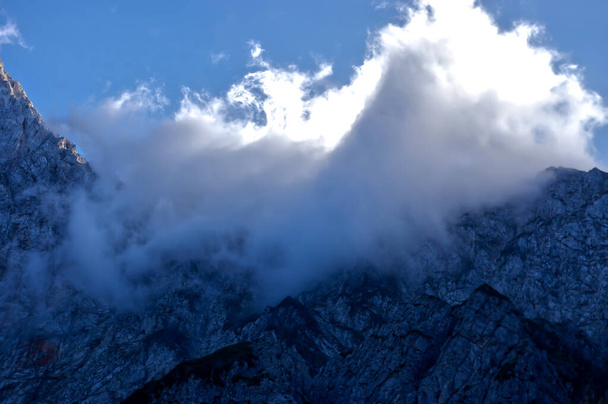 A beautiful view of cloudy rock mountain tops in Logarska Dolina settlement, Logar Valley, Slovenia - Foto, immagini