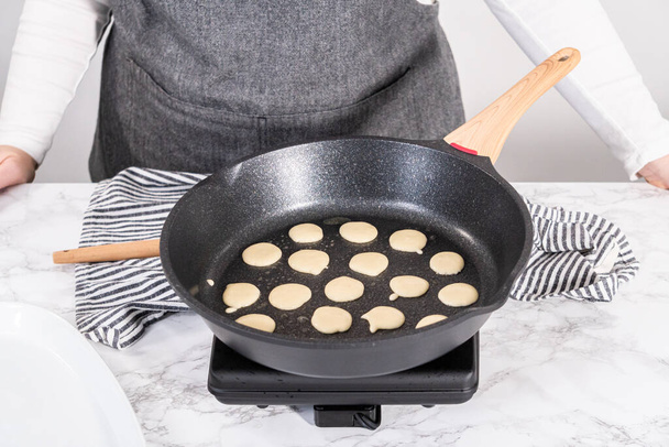 Frying mini pancake cereal in a nonstick frying pan. - 写真・画像