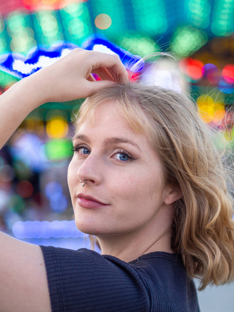 A vertical portrait of a young blonde female at an amusement park - Photo, image